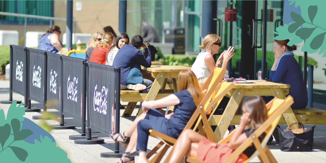 Various people sitting outside a restaurant on a sunny day
